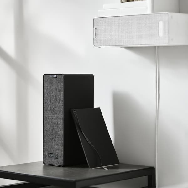 Ein schwarzer und ein weißer SYMFONISK Lautsprecher. Einmal stehend und einmal an der Wand hängend. Artikelnummer: 505.065.73 schwarz, Artikelnummer: 505.065.87 weiß