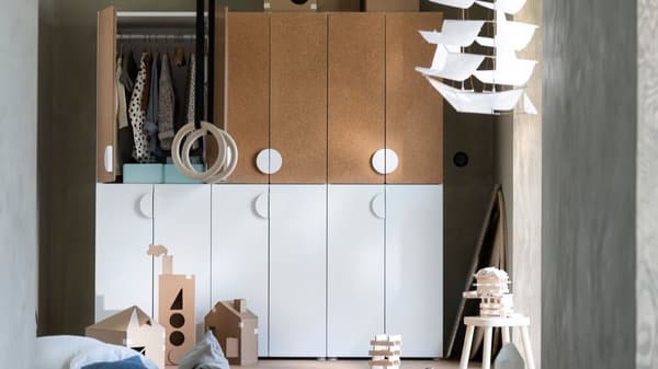 Ein SMASTAD Kleiderschrank steht in einem Kinderzimmer. Die oberen linken Türen sind geöffnet und man kann viel Spielzeug am Boden sehen.