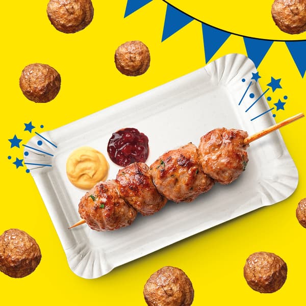 Ein Spieß mit 4 Fleisch(los)bällchen mit 2 verschiedenen Saucen gefüllt mit 4 Fleisch(los)bällchen auf einem gelben Hintergrund mit blauer Girlande. 