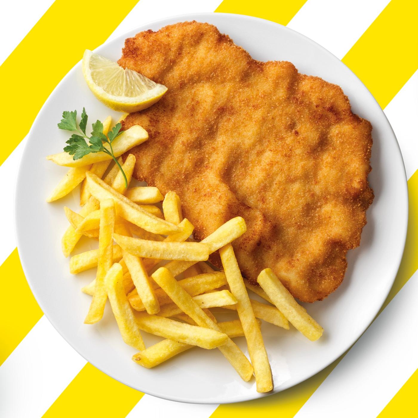 Ein Teller mit einem Putenschnitzel und Pommes vor einem gelb-weiß gestreiften Hintergrund.