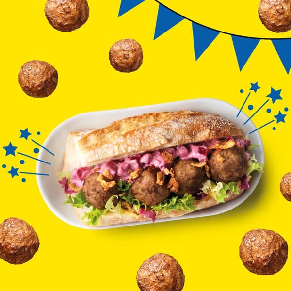 Ein Teller mit einem Sandwich gefüllt mit 4 Fleisch(los)bällchen auf einem gelben Hintergrund mit blauer Girlande.