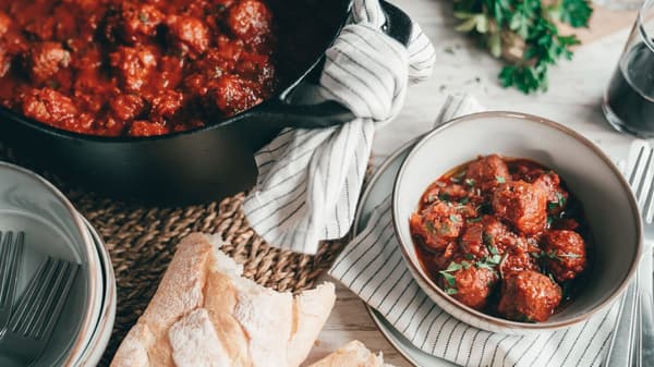 Ein Topf mit PLANTBULLAR Albóndigas steht auf einem Tisch, daneben ist eine Portion in einer Schüssel angerichtet.