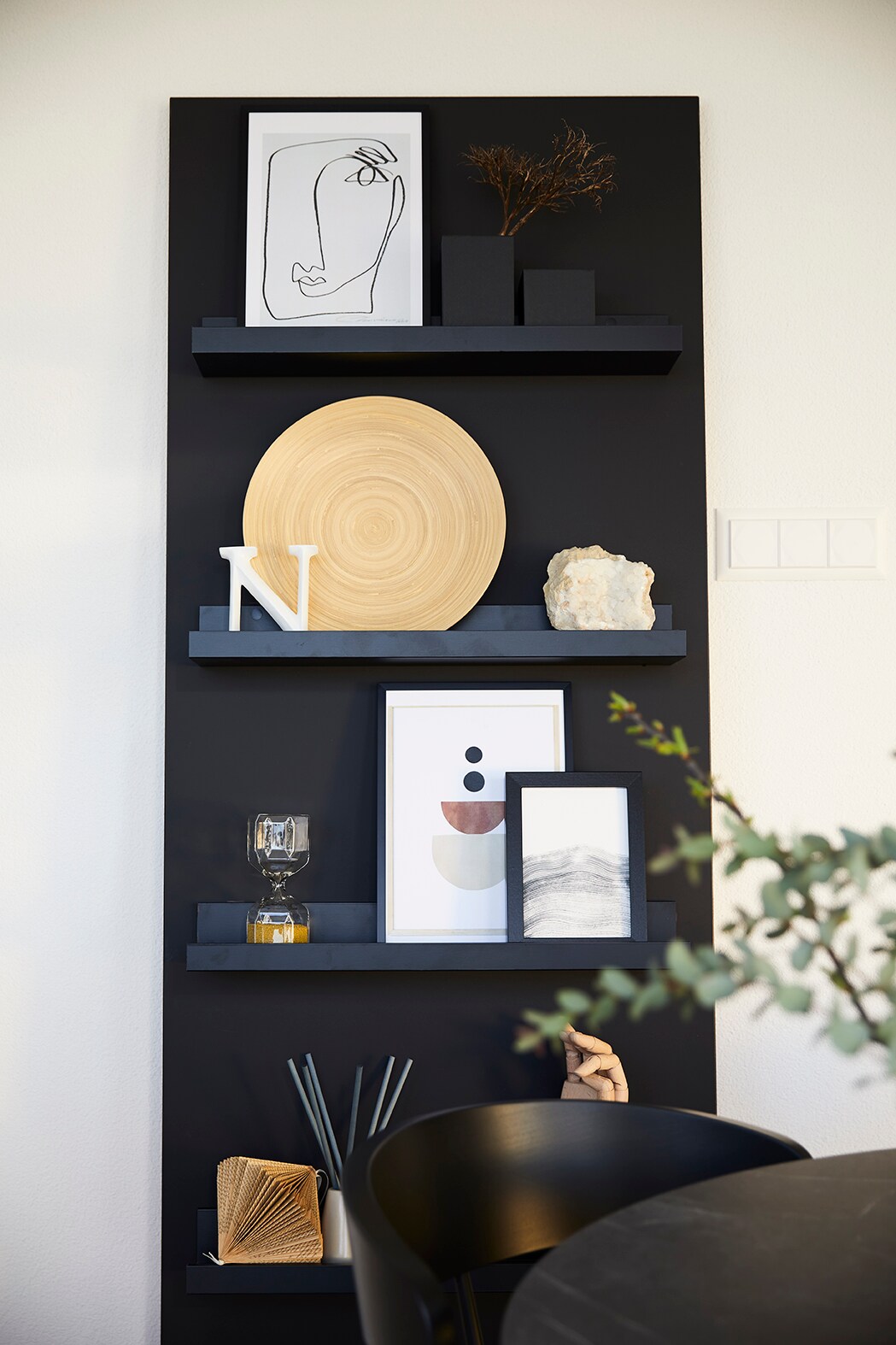 Ein Wandregal mit 4 Ebenen und Vasen, Bilderrahmen, Duftstäbchen und Dekoration