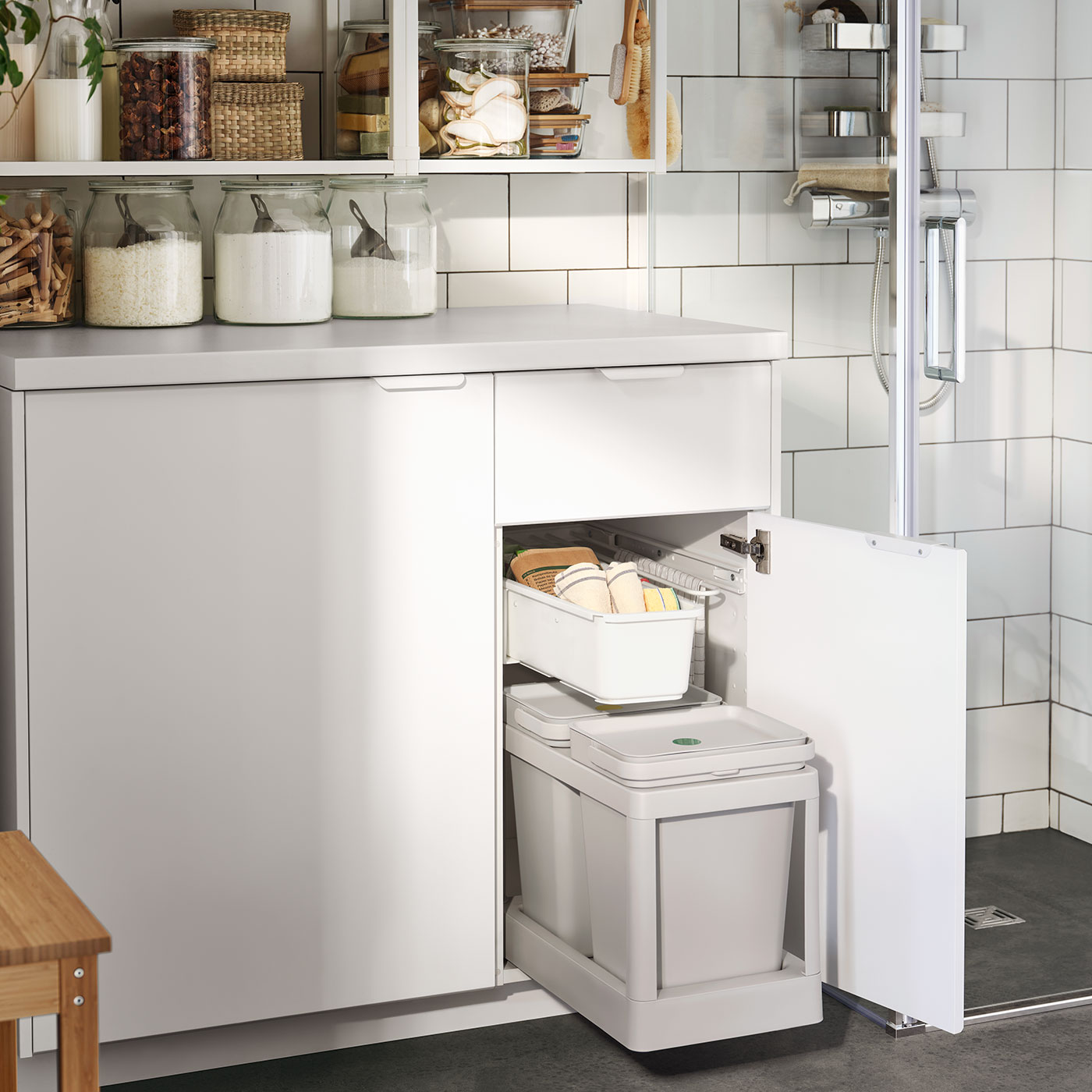 Ein weißer Badezimmerschrank mit eingebauter HALLBAR Abfalltrennungslösung in hellgrau.