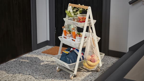 Ein weißer RISATORP Servierwagen mit drei Etagen und einem Holzgriff. Darauf ist ein Frühstück für zwei Personen zu sehen.