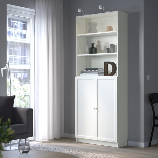 Ein weißes IKEA Billy Regal mit Türen in einem sonnenbelichtetem Raum