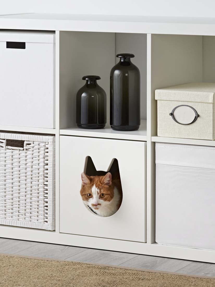 Ein weißes KALLAX Regal 5x5 mit Regalteilern, einer bestickten Gitterbox, Schubladen, Papierboxen und Deko steht vor einer rosefarbenen Wand.