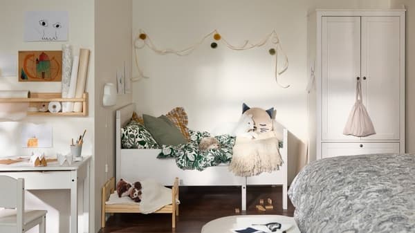 Ein weißes SUNDVIK Kinderbett in einem hellen Kinderzimmer.