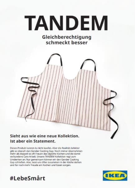 Ein Werbeplakat mit dem Titel "TANDEM" und dem Slogan "Gleichberechtigung schmeckt besser". Es zeigt eine doppelte Schürze, die so aussieht, als wäre sie für zwei Personen gleichzeitig gedacht, auf einem weißen Hintergrund. Darunter steht der Text "Sieht aus wie eine neue Kollektion. Ist aber ein Statement." und ein ausführlicherer Text, der die Idee hinter der "TANDEM"-Schürze und dem Gender Cooking Gap erklärt. Unten links steht "#LebeSmårt" und rechts das IKEA Logo.
