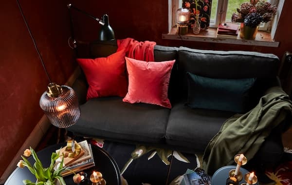 Ein Wohnzimmer mit einer Mischung aus Hänge-, Stand- und Tischleuchten. Ein paar bunte Kissenbezüge ergänzen das Ensemble.