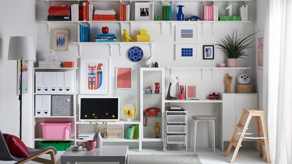 Ein Wohnzimmer mit einer Wand voller Regale und Schränke, die zur Aufbewahrung genutzt wird.