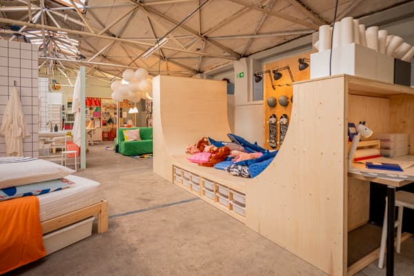 Einblick in den Ausstellungsraum von IKEA auf den Köln Passagen. Rechts im Bild eine Halfpipe aus Holz, links im Bild ein Bett mit Matratze und Kissen.