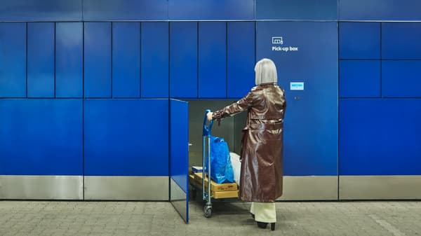 Eine ältere Frau holt ihre Pakete aus der Pick up box ab.
