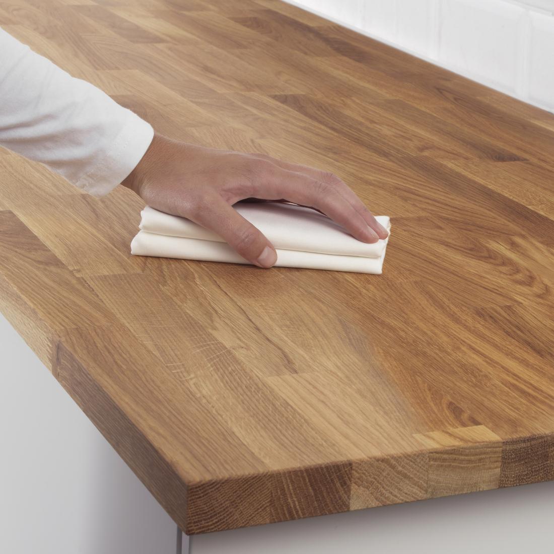 Eine Arbeitsplatte wird von einer Person mit Öl behandelt.