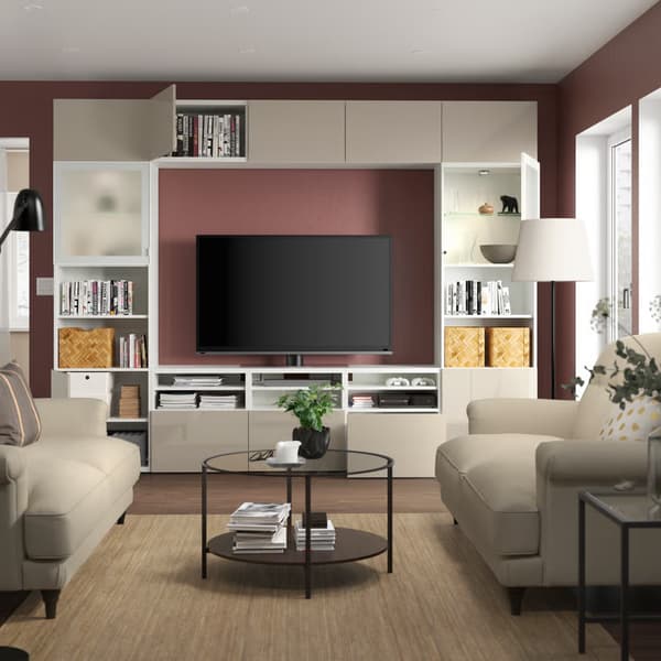 Eine BESTÅ TV-Kombination in Weiß/Selsviken-Hochglanz/beigem Milchglas mit Glastüren im Wohnzimmer.