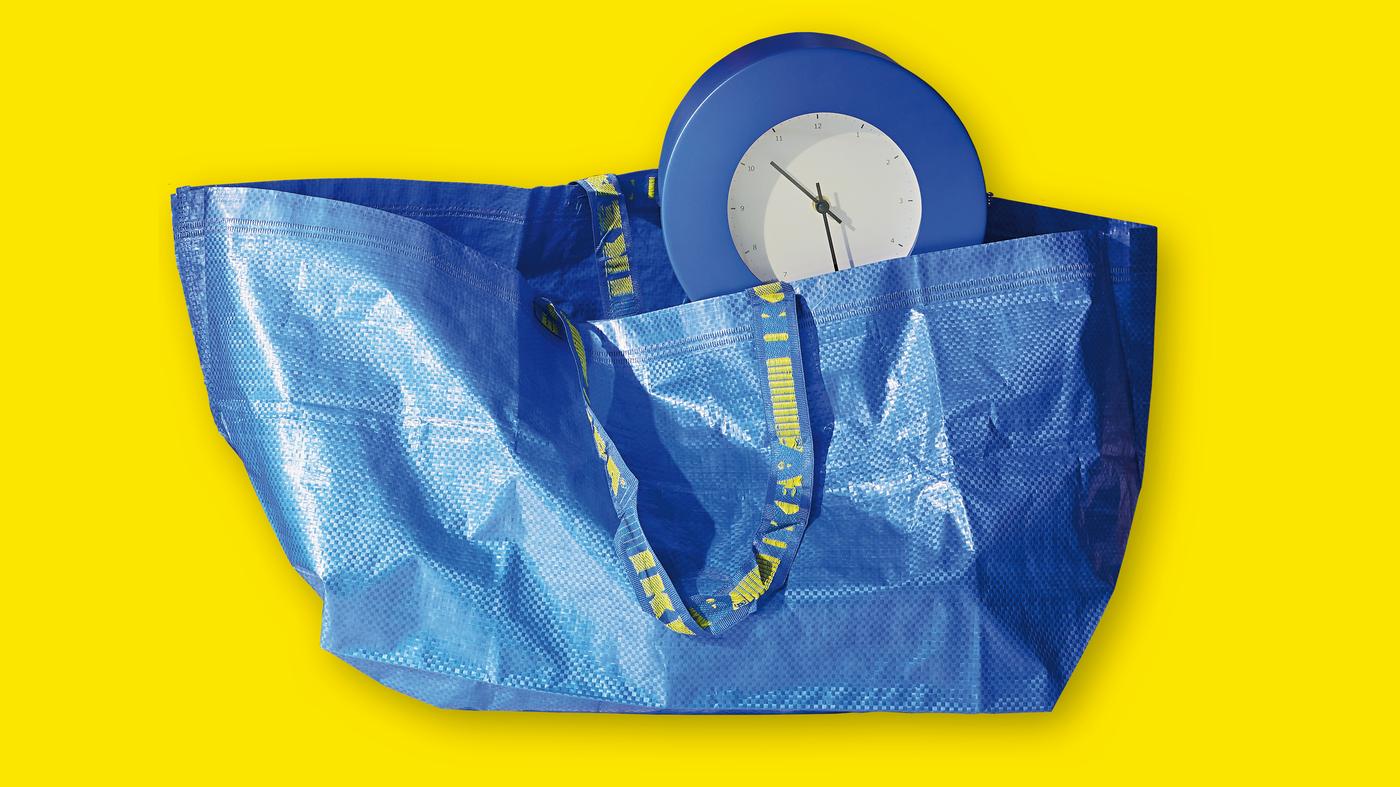 Eine blaue FRAKTA Tasche mit einer blauen Uhr und gelben Hintergrund