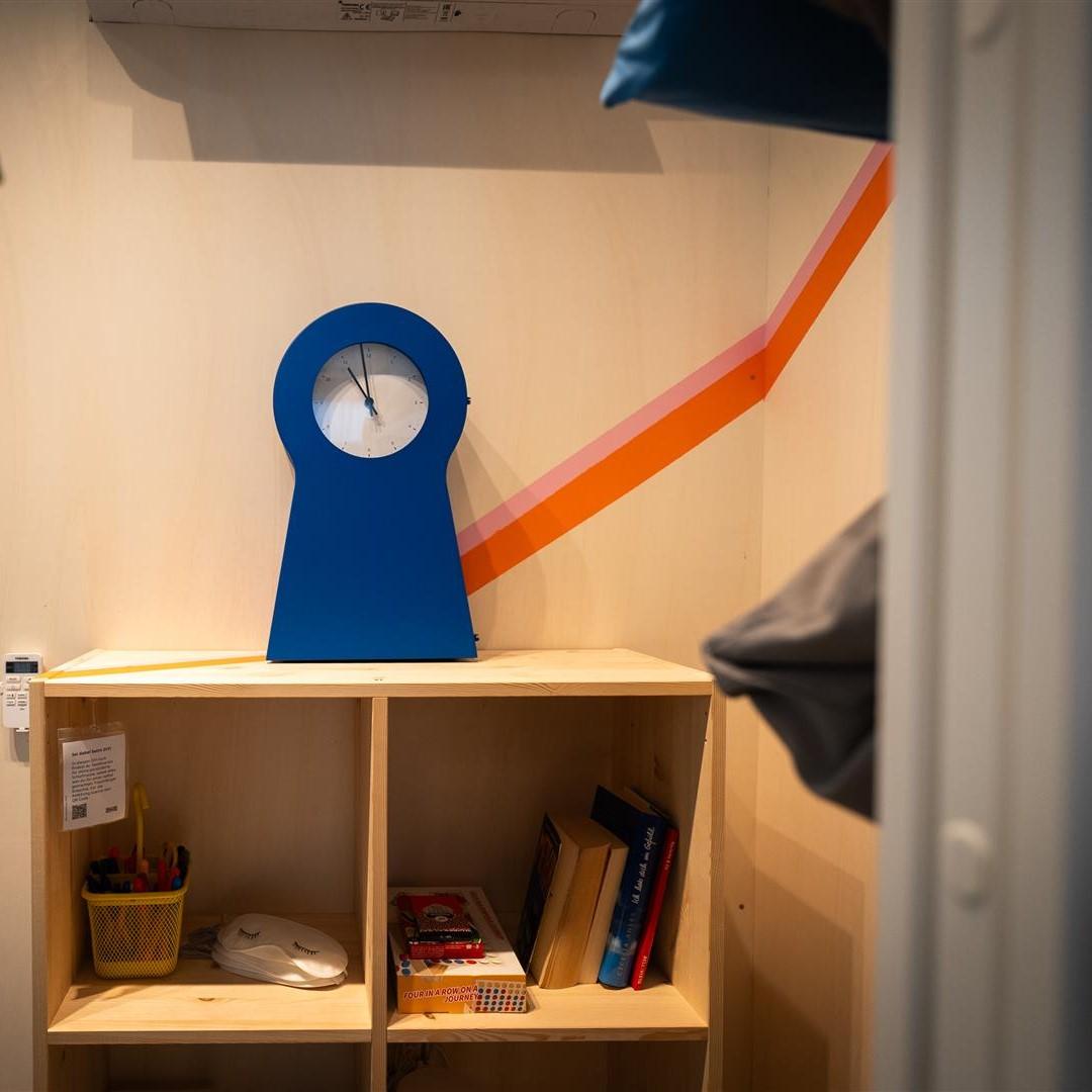 Eine blaue IKEA PS Uhr auf einem kleinen IVAR Regal.