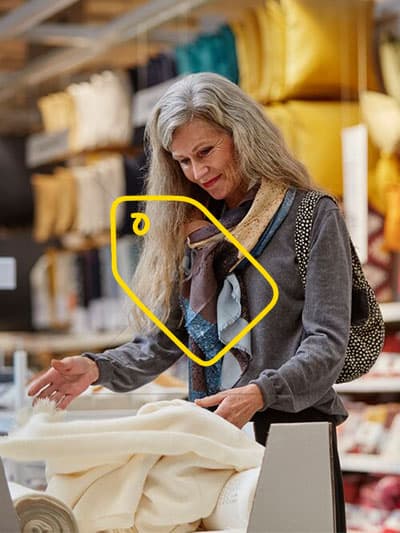 eine Dame in der IKEA Textilien abteilung die sich gerade einen Bezug ansieht.