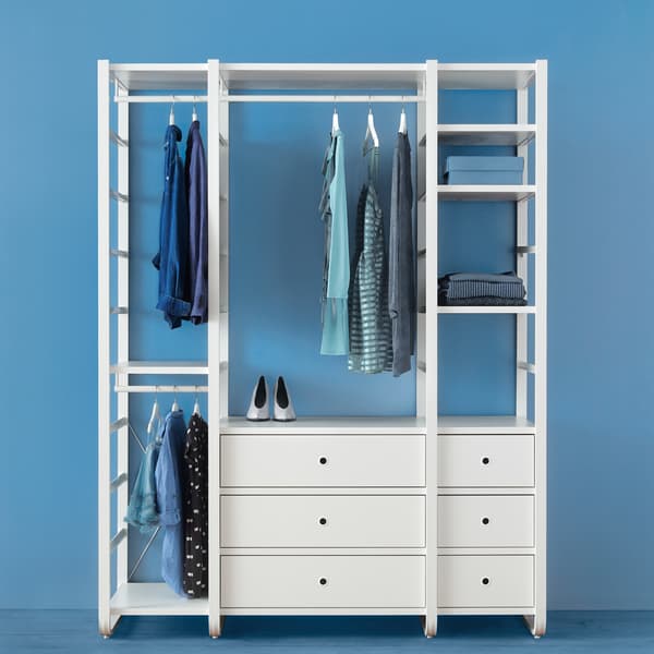 Eine ELVARLI Kleiderschrankkombination in einem blauen Raum. An einer Stange hängen Kleidungsstücke, ansonsten sind noch Taschen und andere Gegenstände zu sehen.