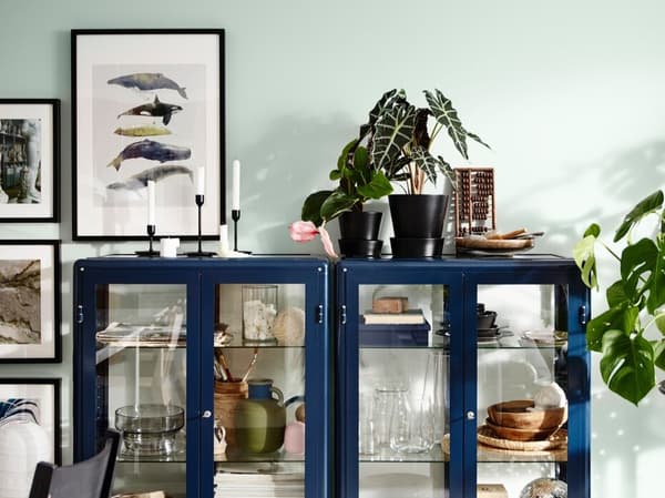 Eine FABRIKÖR Vitrine in Blau hübsch dekoriert in einem Wohnzimmer.