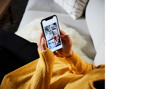 Eine Frau hat ein Smartphone in der Hand und die IKEA App geöffnet.