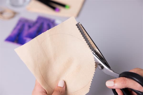 EIne Frau schneidet einen Kreis aus Papier aus