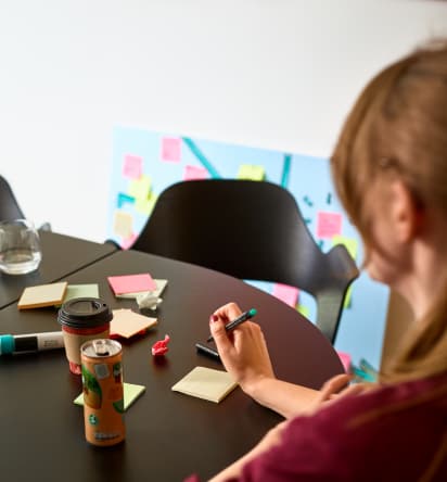 Eine Frau sitzt an einem Tisch und macht sich Notizen