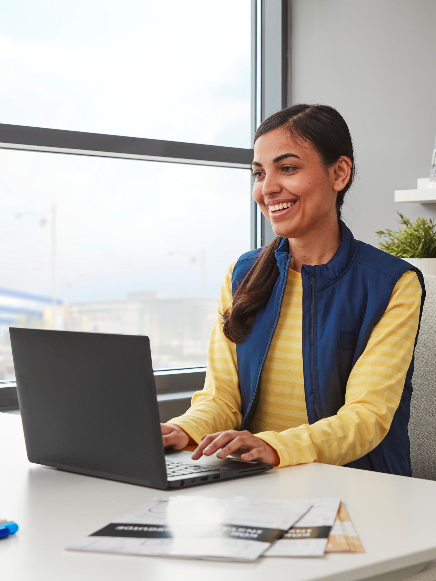 Eine Frau sitzt vor dem Computer und plant das Design.