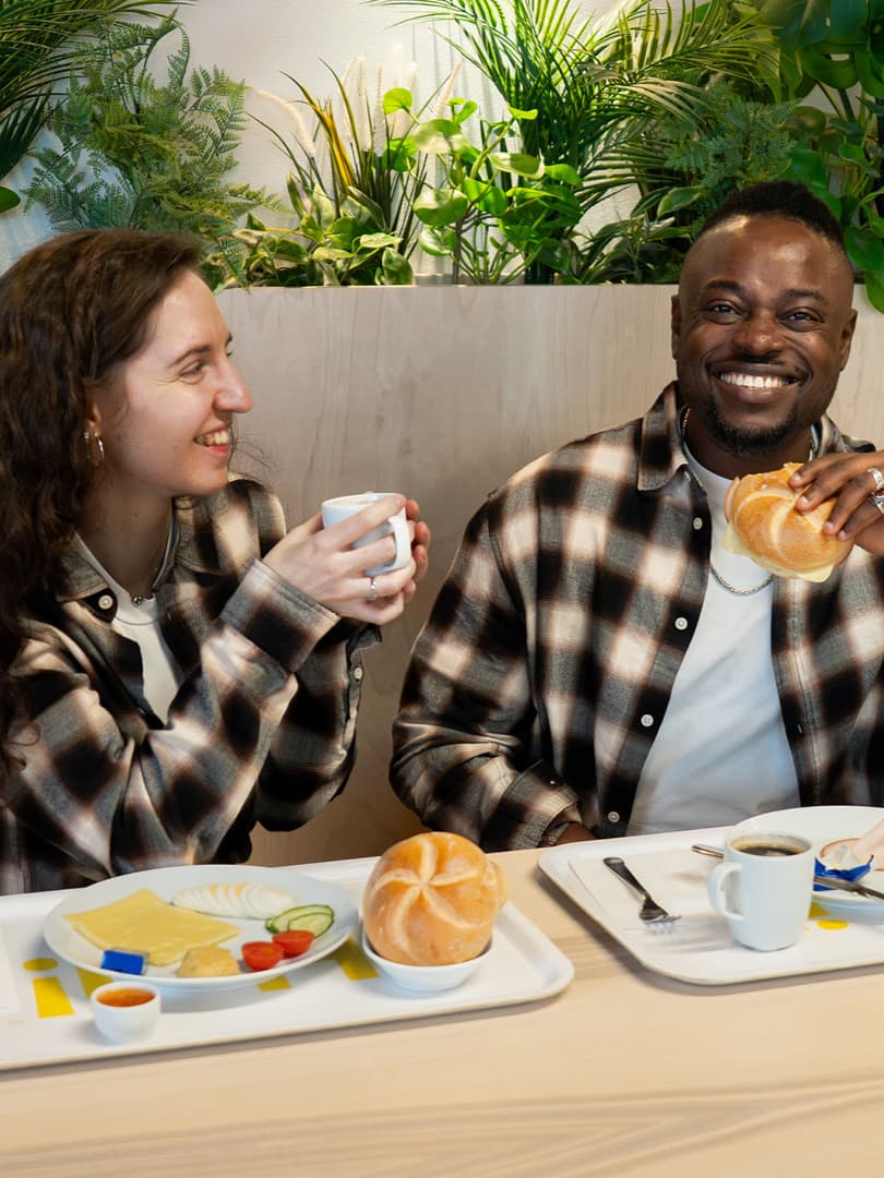 Eine Frau und ein Mann, die im IKEA Restaurant sitzen und frühstücken