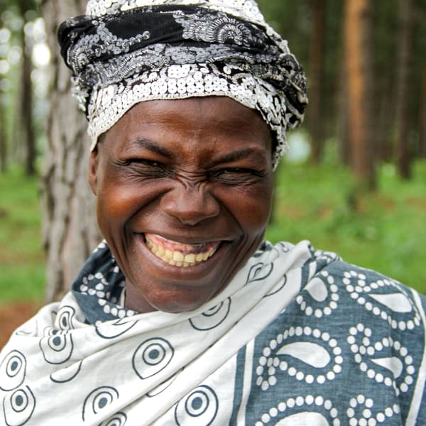 Eine fröhlich lächelnde Frau aus Uganda, die in das Projekt Weisser Nil involviert ist