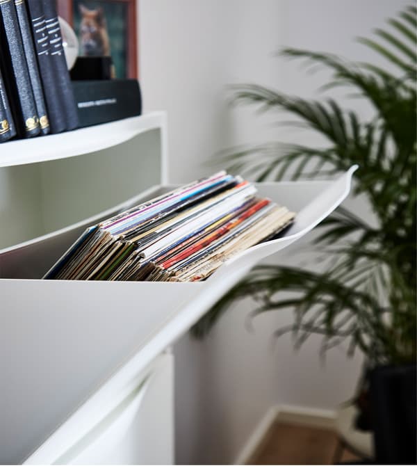 Eine geöffnete TRONES Aufbewahrung in Weiss, in der ein Stapel Schallplatten zu sehen ist.