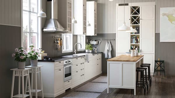 Eine große weiße IKEA Küche mit Dekopflanzen und passenden Hängeleuchten