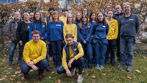 Eine Gruppe von Menschen auf dem Rasen vor der Tagesstätte darunter Helfer aus der Tagesstätte der Weg und IKEA Mitarbeitende, die an diesem Tag zusammen die Verschönerung durchgeführt haben.