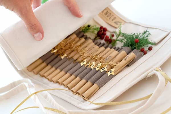 Eine Hand rollt den Adventskalender auf.