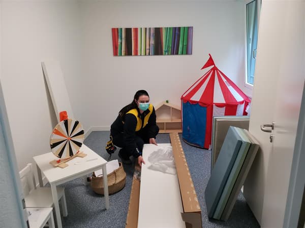Eine IKEA Mitarbeiterin packt ein Möbelstück in der Herberge für Frauen in Zug aus, um es zu montieren