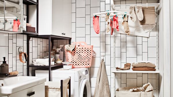 Eine im Badezimmer eingerichtete Waschküche mit Waschmaschine, Aufbewahrung für Wäsche mit Schrank und einer Wäschekombination mit Boden.
