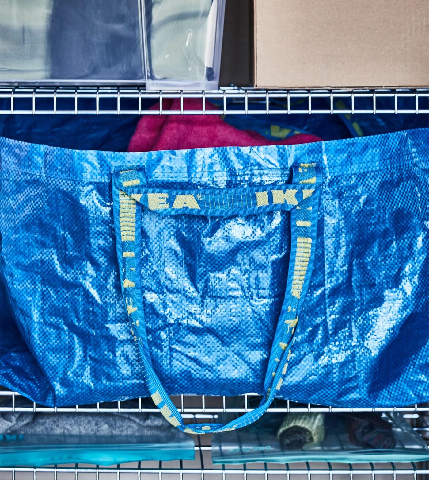 Eine klassische IKEA Einkaufstasche, u. a. in OMAR Regalelement.