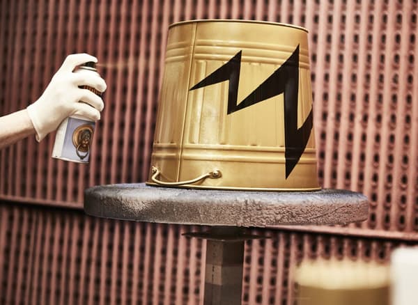 Eine KNODD Tonne wird mit goldener Farbe besprüht