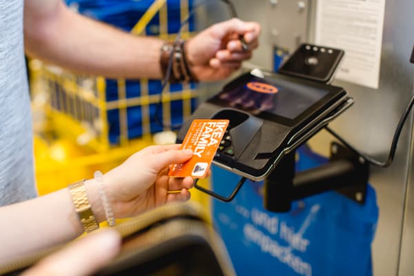 Eine Kundin hält ihre IKEA Family Card vor das Bezahlgerät.