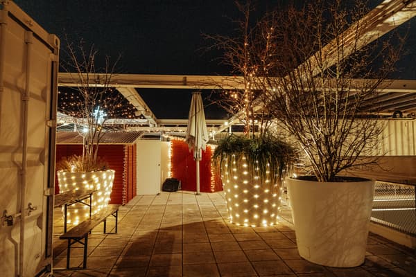 Eine mit LED Lichtern Geschmücke große Vase steht inmitten eines Weihnachtsmarkets.