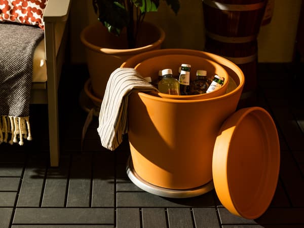 Eine orangene Box steht auf dem Boden und kühlt Flaschen ohne Strom.