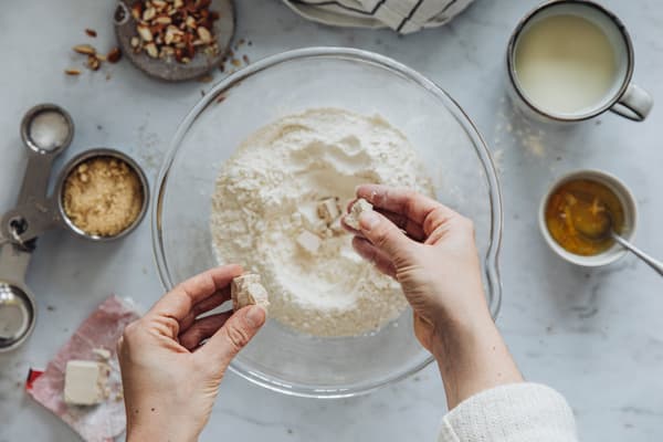 Eine Person bereitet den Teig für vegane Hefeknoten mit Apfelcider-Karamell zu.