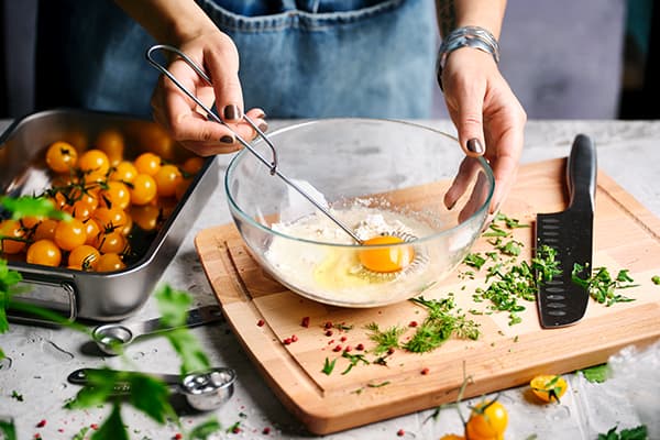 Eine Person bereitet den Teig für vegetarische herzhafte Waffeln zu.