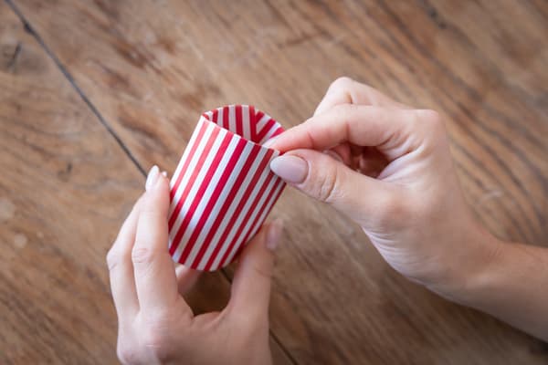 Eine Person faltet den oberen Bereich einer Geschenkverpackung um.