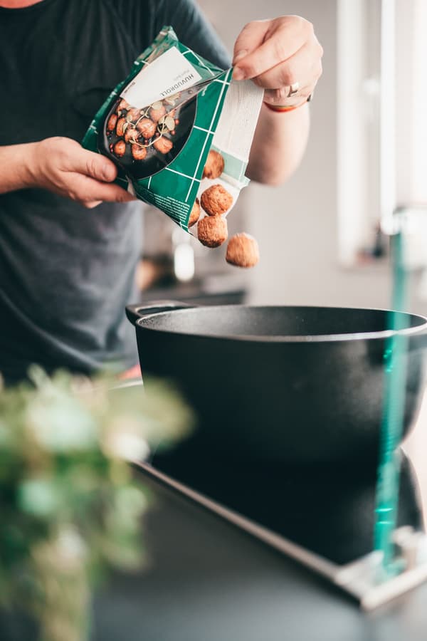 Eine Person gibt PLANTBULLAR zum Braten in einen Topf.