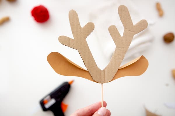 Eine Person hält ein gebasteltes Rentiergeweih in der Hand.