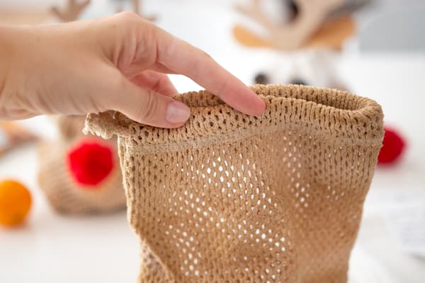 Eine Person hält ein Stoffsäckchen in der Hand.
