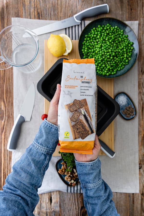 Eine Person hält eine Brotbackmischung in der Hand.