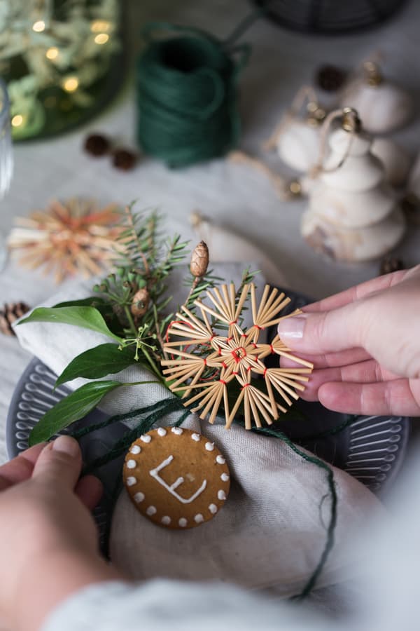 Eine Person hält weihnachtliche gestaltete Namensschilder in der Hand.