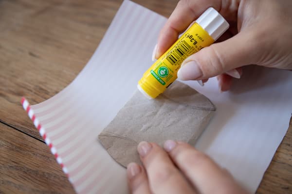 Eine Person klebt ein Stück Papier auf.